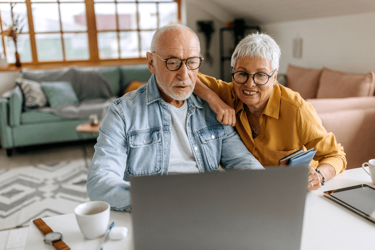 An elderly couple looking at a laptop