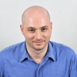 Photo of a man with his head tilted forward.